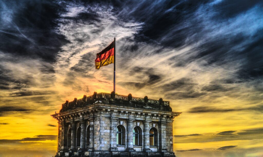 Niemiecka flaga na szczycie zabytkowego budynku.